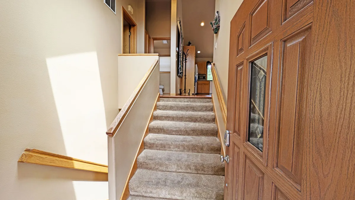 A welcoming entryway with a staircase and front door, adorned with warm decorative elements. The layout hints at the excitement of arrivals—greeting friends or family and gathering before setting out for Sunriver adventures.